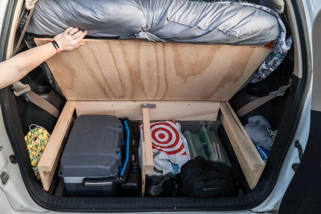 An open bed platform shows food storage in the back of a Rav 4